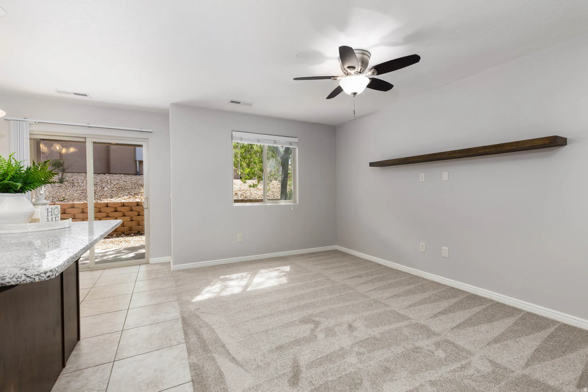 Family room with a ceiling fan and carpet