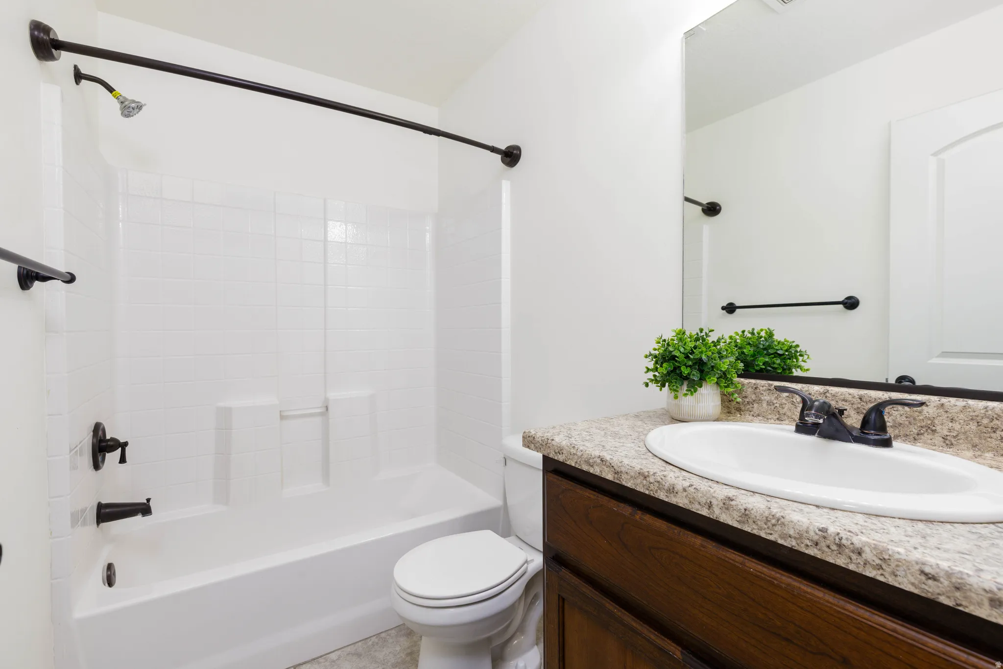 Bathroom featuring vanity and shower / washtub combination, granite counter
