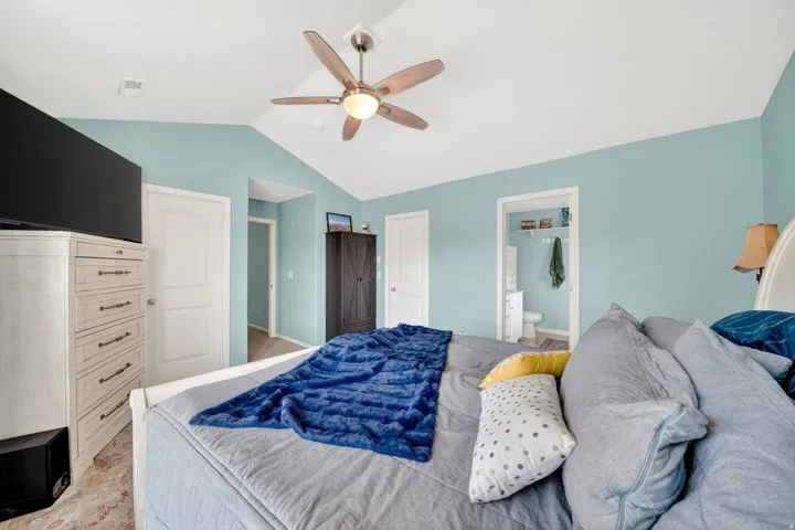 Bedroom with ceiling fan, ensuite bathroom, and a closet
