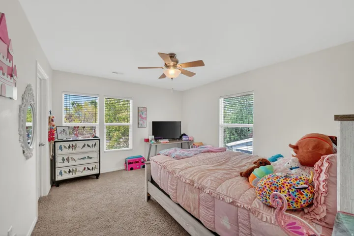 Bedroom with light colored carpet and ceiling fan