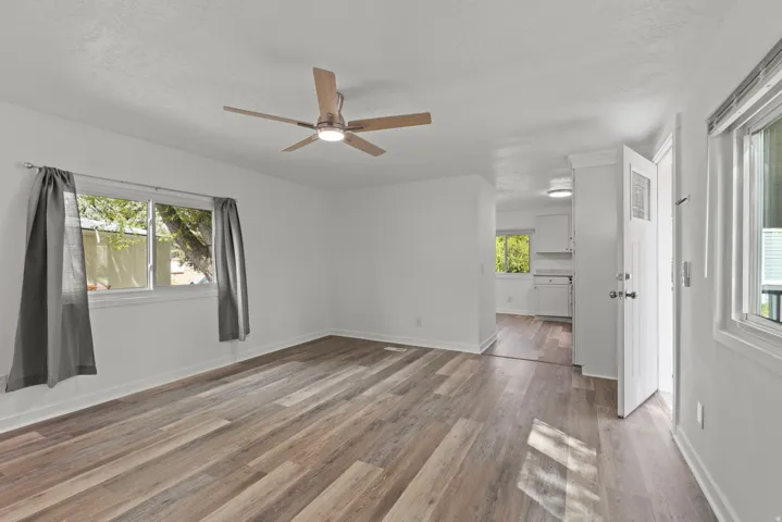 Spare room with plenty of natural light, dark wood finished floors, a ceiling fan, and a textured ceiling