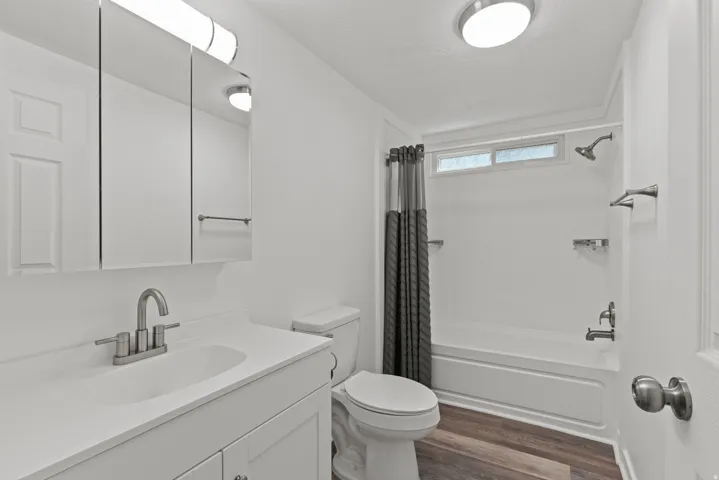 Full bath with vanity, dark wood-style floors, shower / bath combo, and a textured ceiling