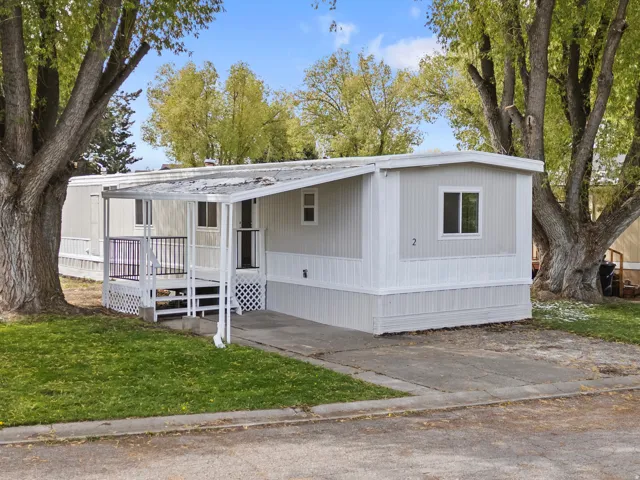 Manufactured / mobile home with covered porch and a front yard