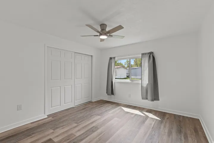 Unfurnished bedroom featuring a closet, light wood-type flooring, and a ceiling fan