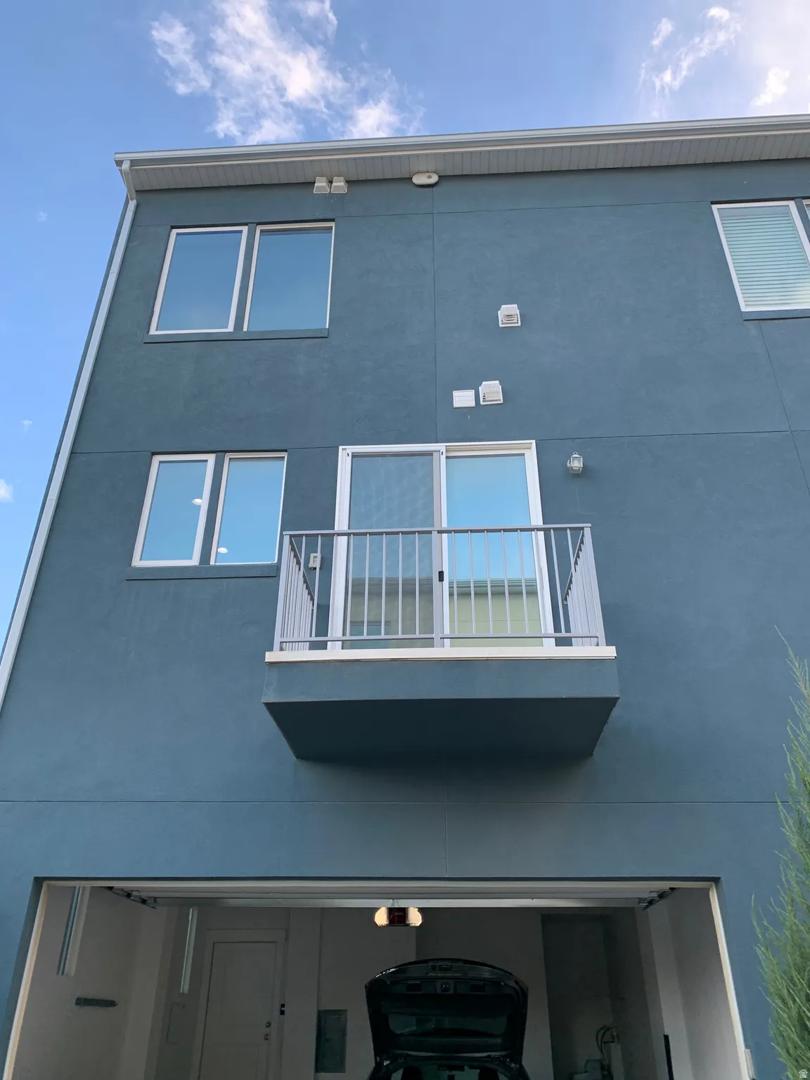 View of building exterior featuring a garage, covered vents