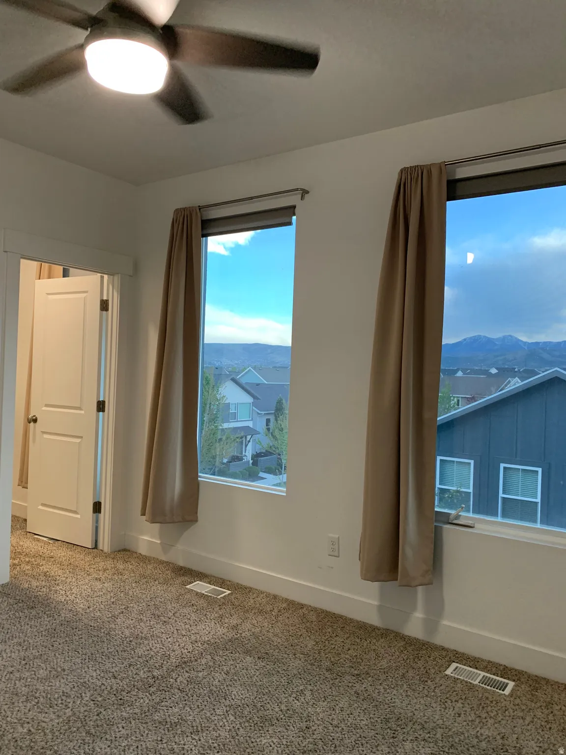 master bedroom featuring a mountain view, ceiling fan, and carpet flooring