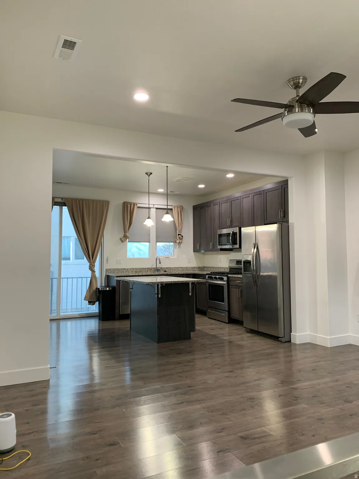 Kitchen featuring stainless steel appliances, ceiling fan, hanging light fixtures