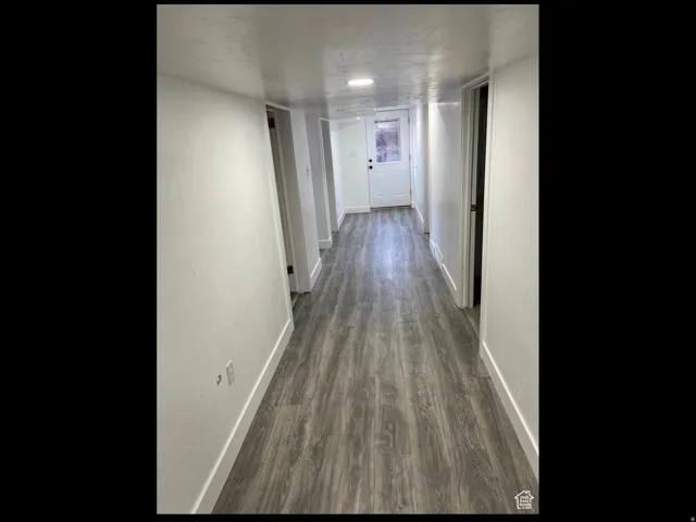 Corridor featuring baseboards and wood finished floors
