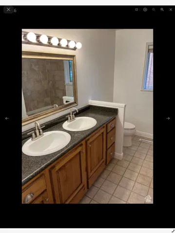 Full bathroom with double vanity and light tile patterned flooring