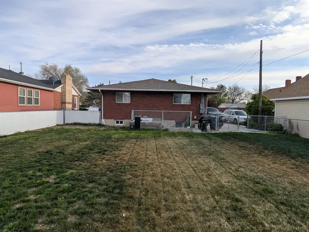 Rear view of house with a patio, brick siding, and a fenced backyard