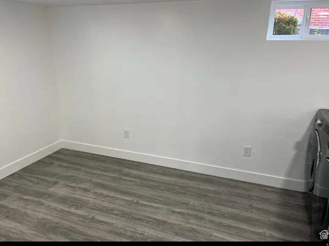 Spare room with dark wood-style floors and washer / clothes dryer