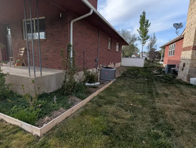 View of property exterior with a lawn and brick siding