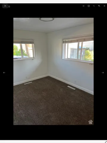Spare room with dark colored carpet and healthy amount of natural light