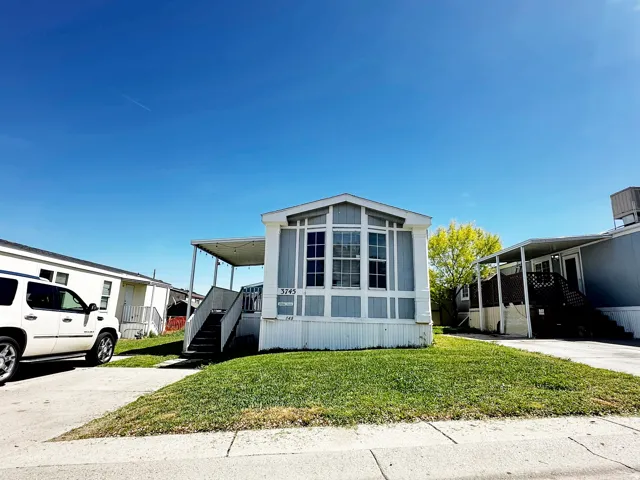 Light blue exterior with white trim and a prominent bay window