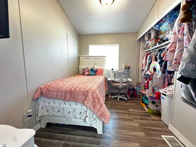 Bedroom with dark wood finished floors, a closet, and a textured ceiling