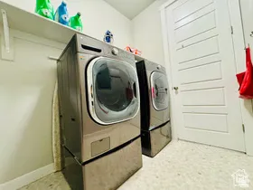 Laundry area featuring separate washer and dryer and light floors