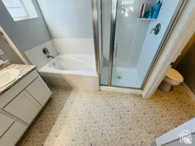 Primary bathroom featuring vanity, a shower stall, and a bath