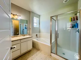 Primary Bathroom featuring vanity, a stall shower, a garden tub, and light flooring