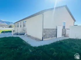 View of property exterior with stucco siding, stone siding, and a mountain view