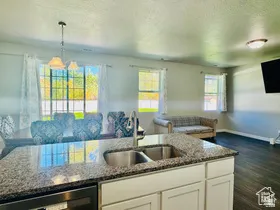 Kitchen featuring open floor plan, dark stone counters, white cabinets, and a textured ceiling