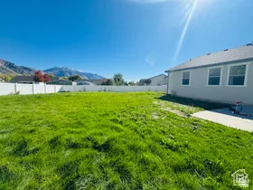 Fenced yard featuring a mountain view and a patio area