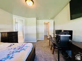 Primary Bedroom featuring dark carpet and an office area