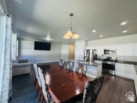 Dining room with dark wood-type flooring and recessed lighting