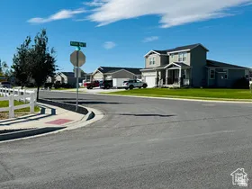 View of west street featuring traffic signs, sidewalks, a residential view, and curbs