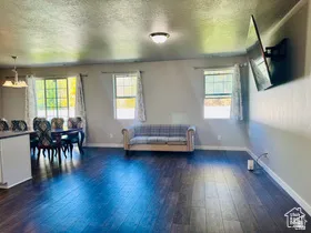 Living area with dark wood-style flooring and a textured ceiling