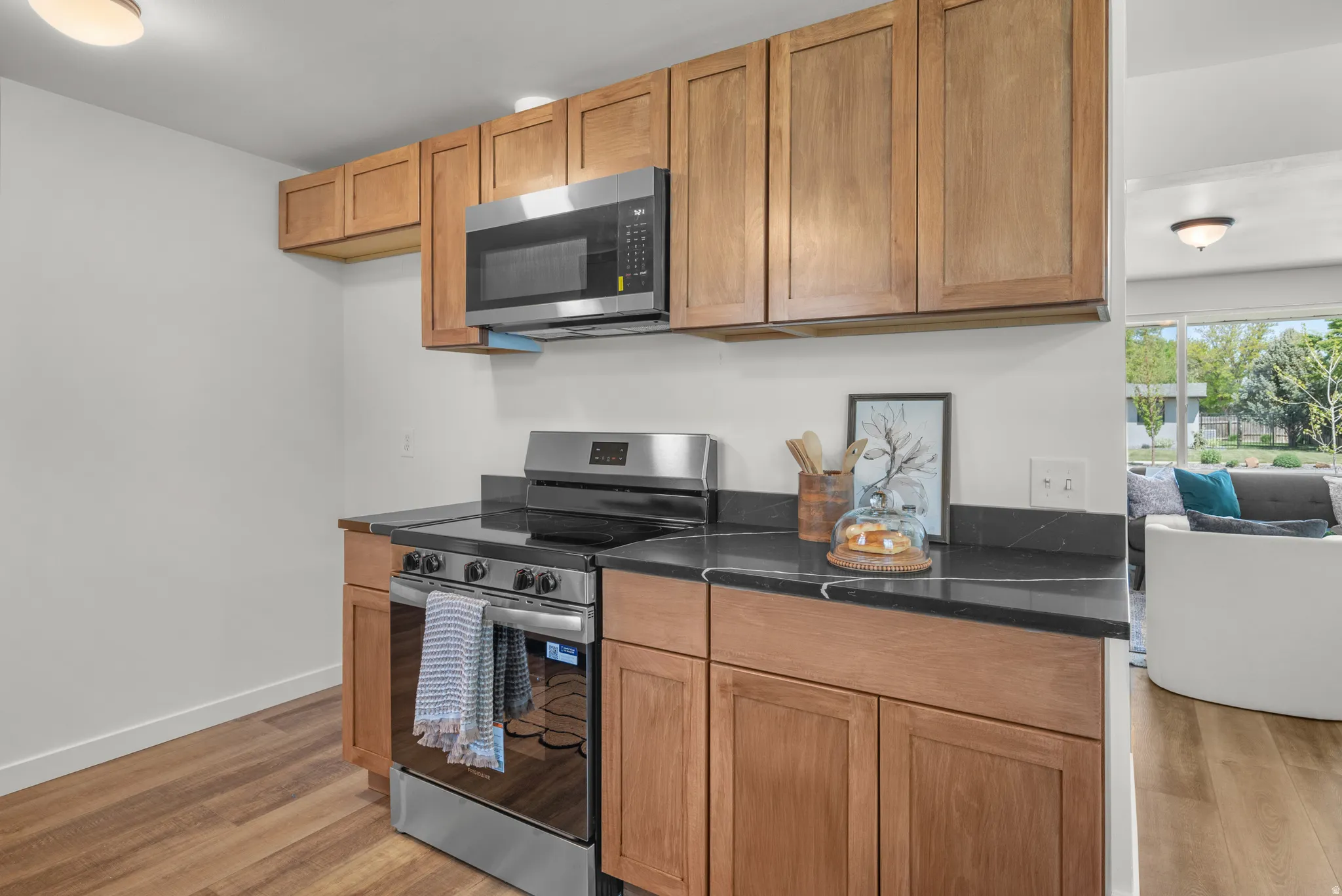Kitchen with stainless steel appliances, wood finish cabinetry, and light wood finished floors