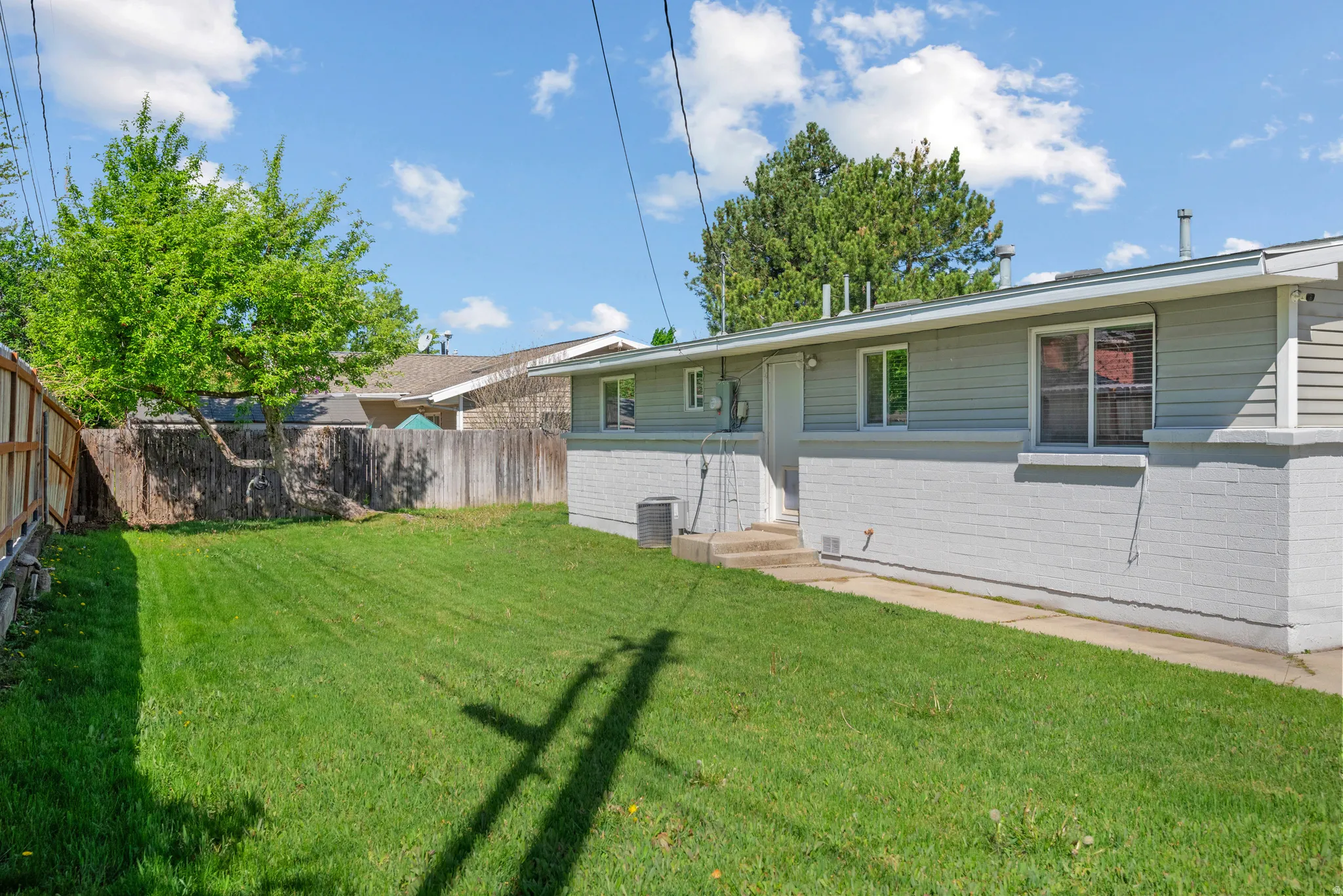 Rear view of house featuring a fenced backyard