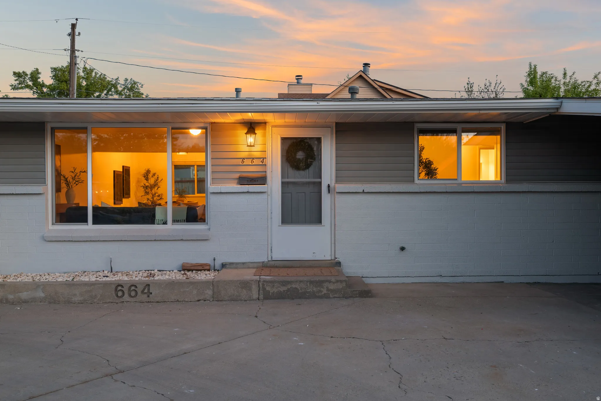 View of front of property featuring a chimney, entry steps, and concrete block siding