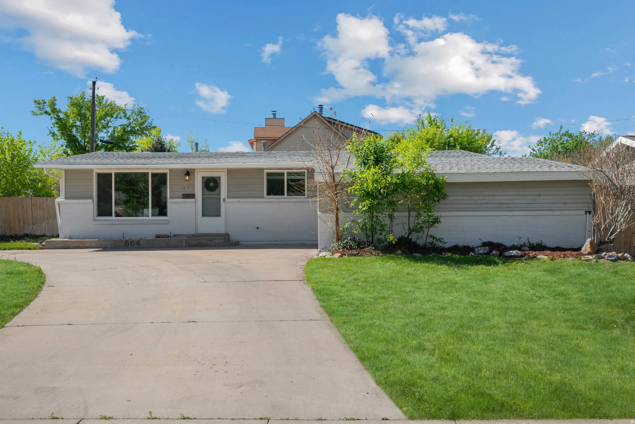 Ranch-style house featuring concrete driveway, brick siding, and a shingled roof