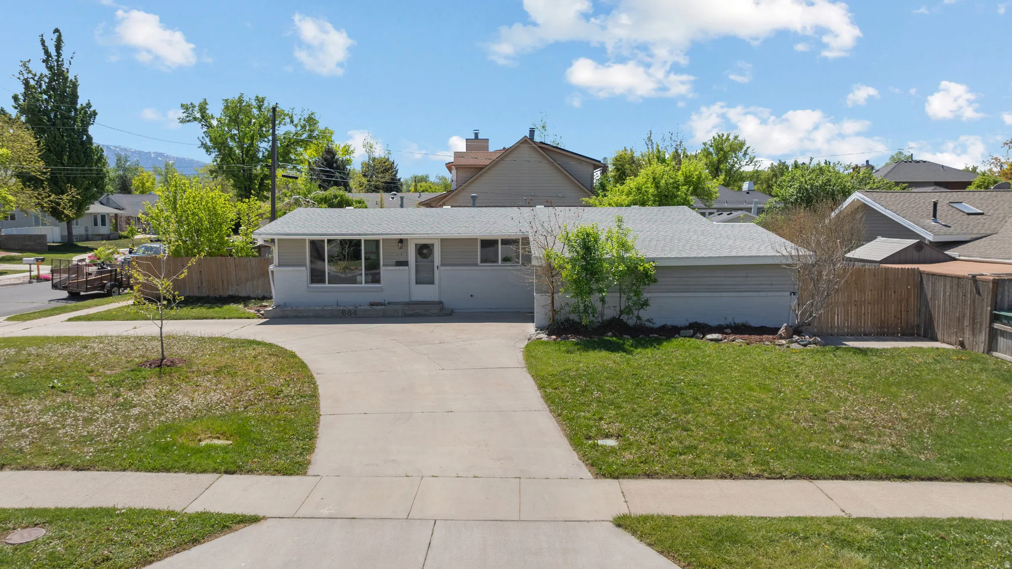 View of front of property with covered porch, curved driveway, and a residential view