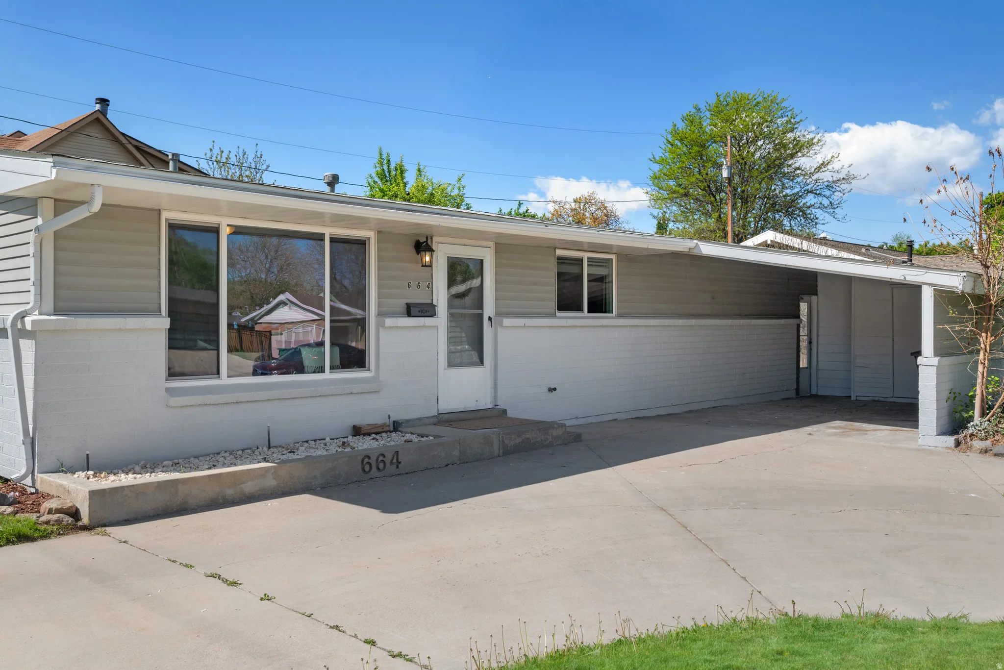 View of front of house featuring an attached carport and driveway