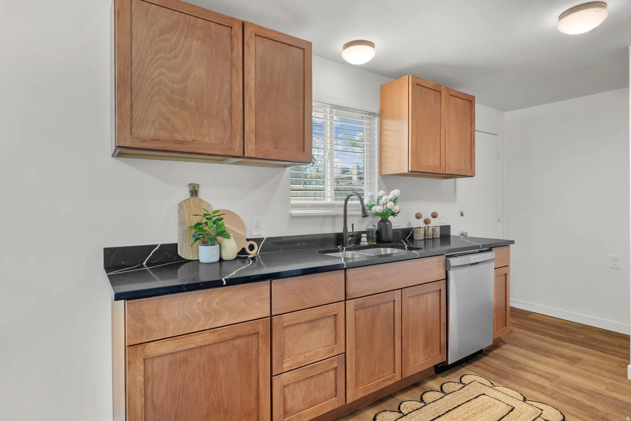 Kitchen featuring light wood-style flooring and stainless steel dishwasher