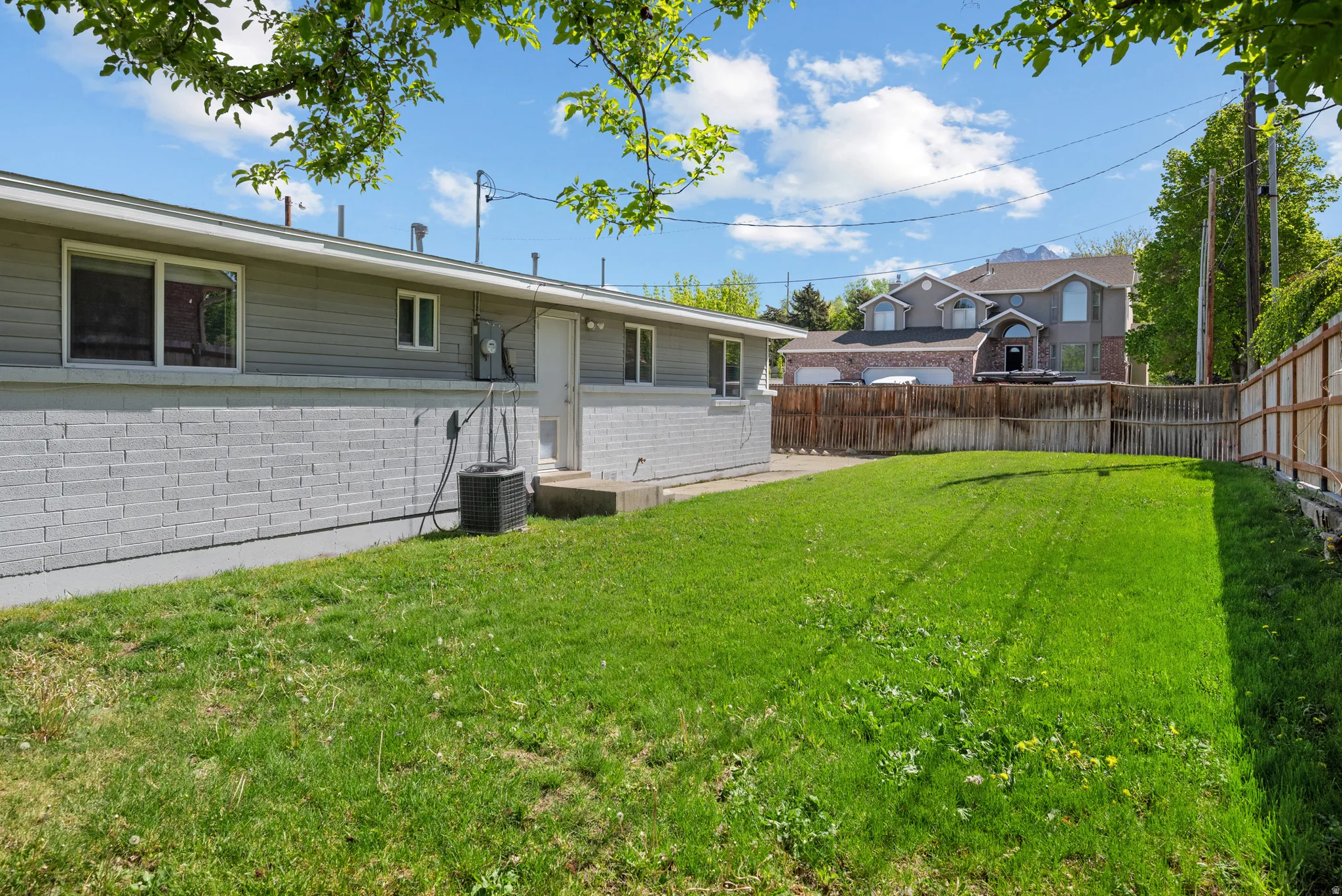 Rear view of house featuring a fenced backyard and brick siding
