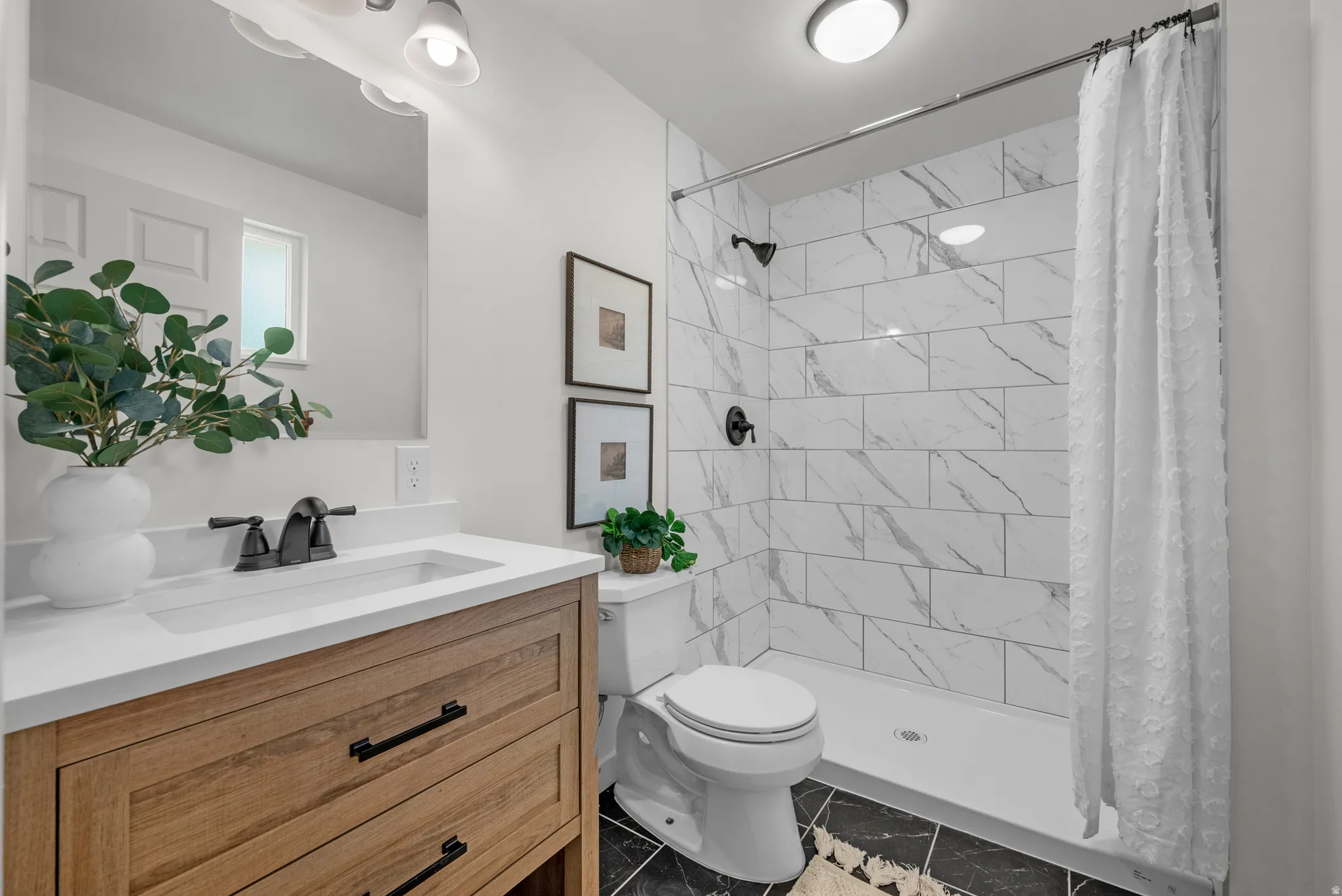 Full bath with vanity, a stall shower, and light marble finish floors