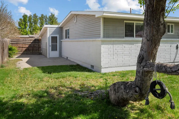 View of side of home featuring a fenced backyard, crawl space, a patio, and brick siding