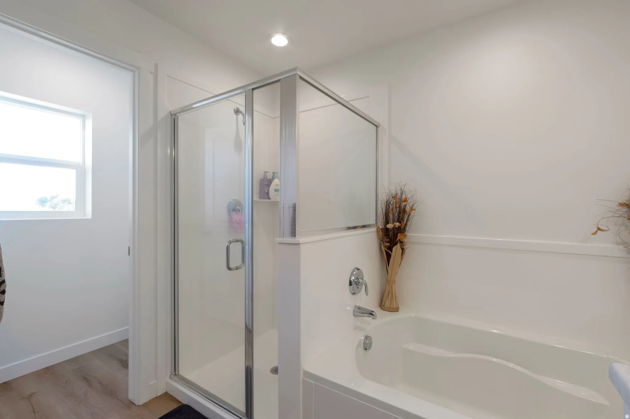 Full bathroom featuring a shower stall, a bath, light wood-type flooring, and recessed lighting