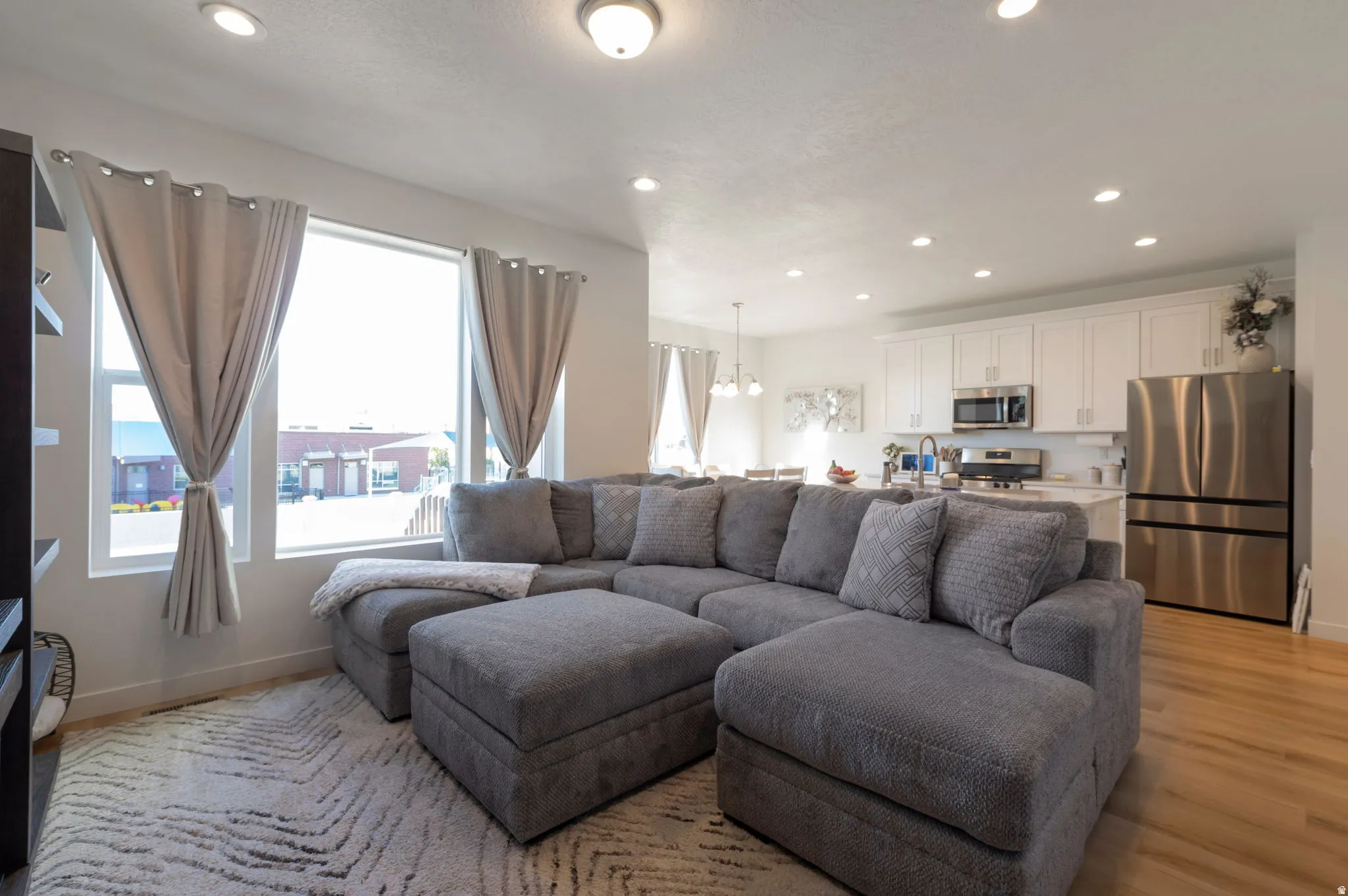 Living room featuring light wood finished floors and hanging lights