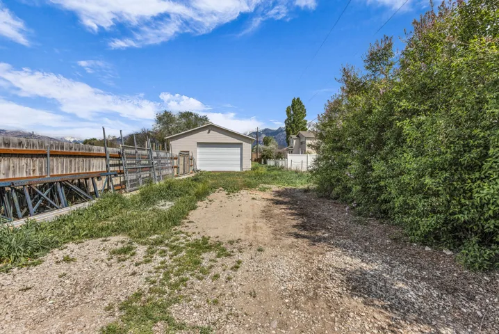 View of yard featuring an outbuilding, a detached garage, driveway, and a mountain view