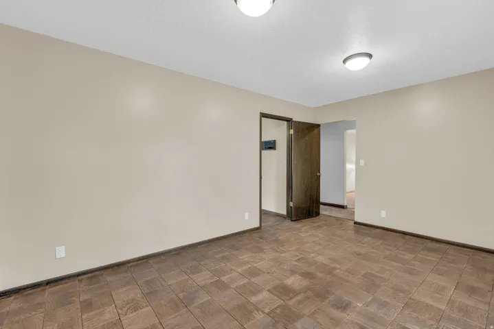 Empty room featuring parquet flooring and baseboards