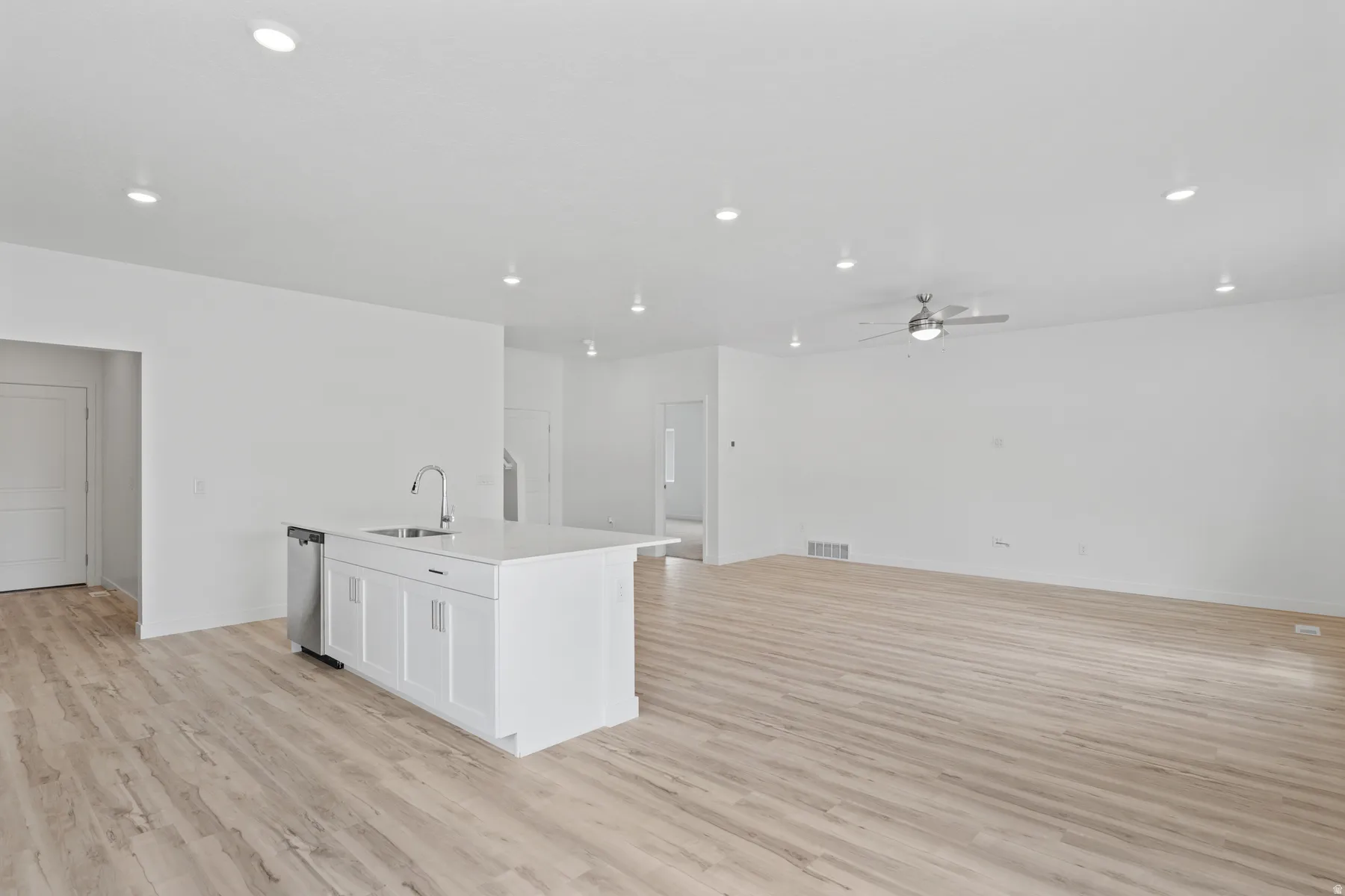 Open-concept living space with light wood-finish flooring