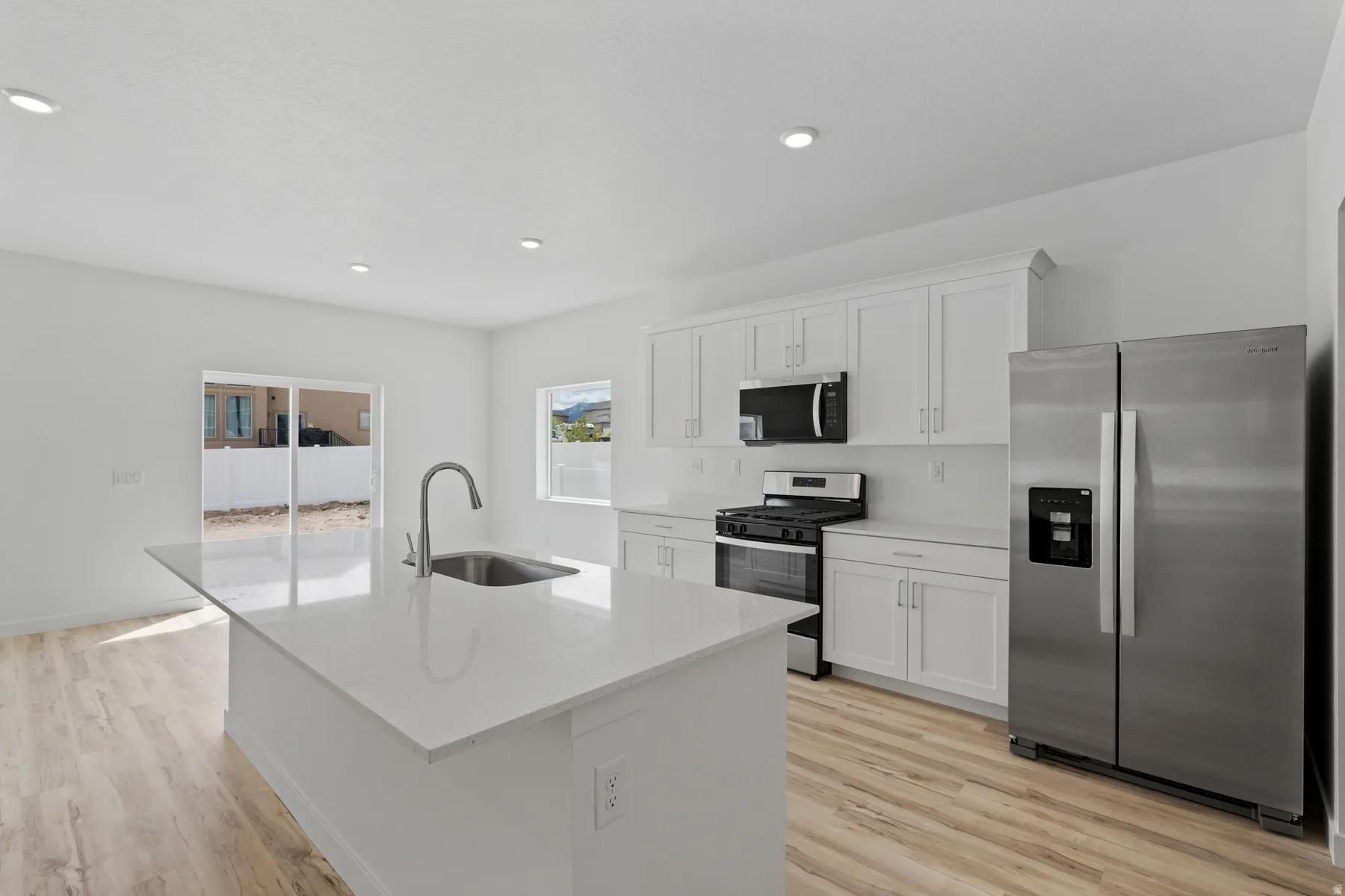 Contemporary kitchen featuring a large central island with an undermount sink and gooseneck faucet