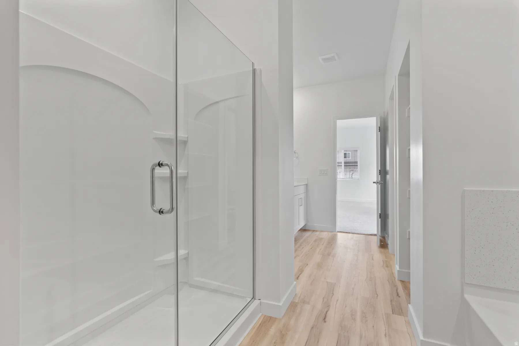 Clear glass shower enclosure with chrome hardware