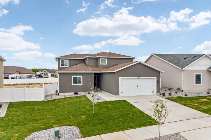 Two-story stucco residence featuring an attached two-car garage