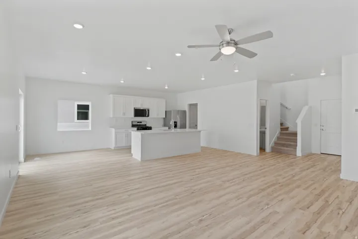 Open-concept living space featuring wood-finish flooring, recessed lighting, and a modern ceiling fan