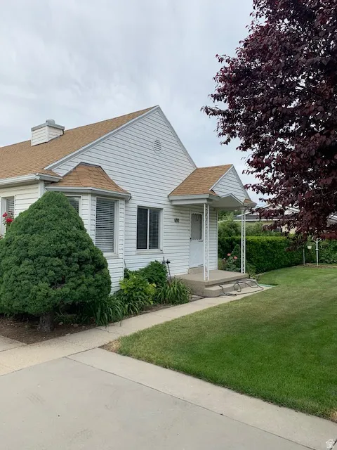 Bungalow-style house with a front yard and roof with shingles