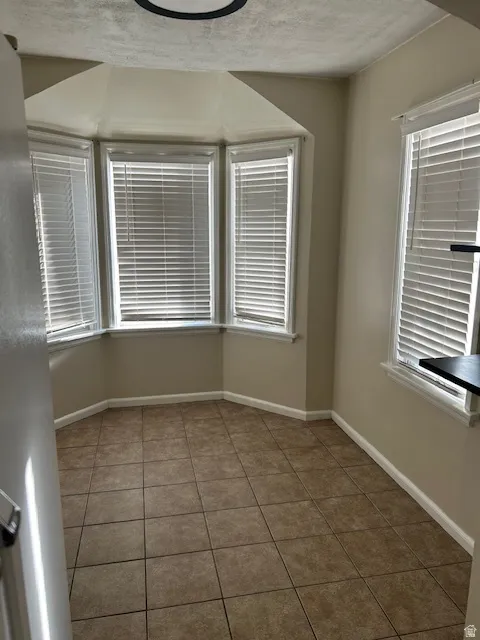 Spare room with dark tile patterned floors and a textured ceiling